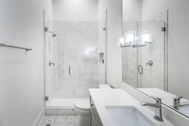 bathroom featuring vanity, toilet, and an enclosed shower