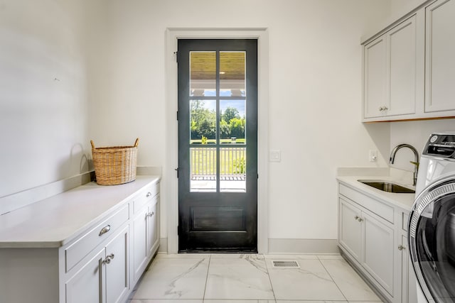 laundry area with washer / clothes dryer, cabinets, and sink