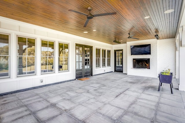 view of patio / terrace featuring ceiling fan and a brick fireplace