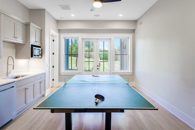 game room with ceiling fan, sink, light wood-type flooring, and french doors