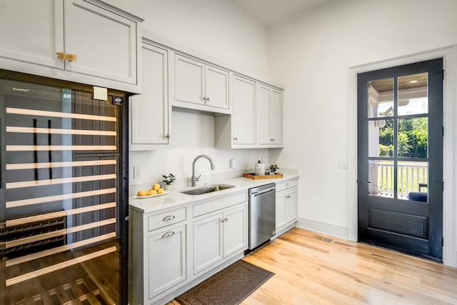 kitchen with stainless steel dishwasher, light hardwood / wood-style flooring, wine cooler, and sink