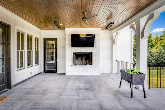 view of patio / terrace with ceiling fan and an outdoor brick fireplace