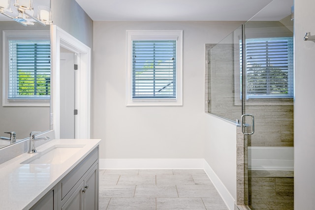 bathroom featuring a wealth of natural light, shower with separate bathtub, and vanity