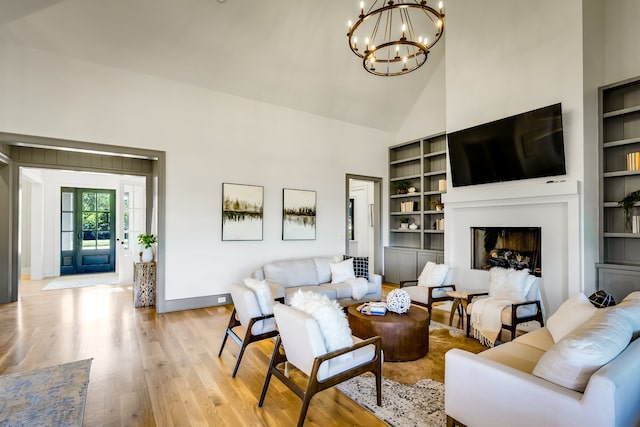 living room featuring high vaulted ceiling, an inviting chandelier, and light wood-type flooring