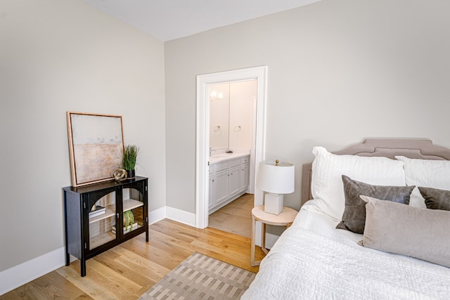 bedroom with light hardwood / wood-style flooring and ensuite bath