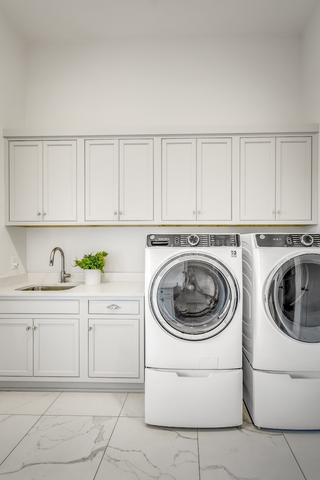 laundry room featuring cabinets, washer and clothes dryer, and sink