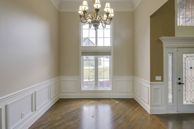 foyer entrance with ornamental molding, dark hardwood / wood-style floors, and a notable chandelier