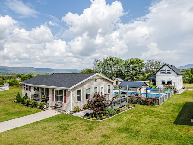 back of property featuring a mountain view, a yard, and a patio