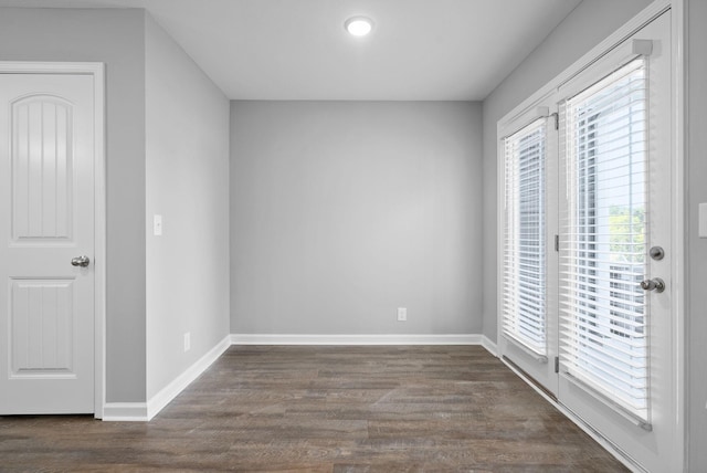 empty room with baseboards and dark wood-style flooring