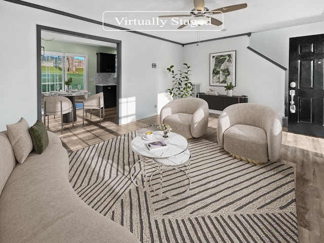 living room with ceiling fan, wood-type flooring, and ornamental molding