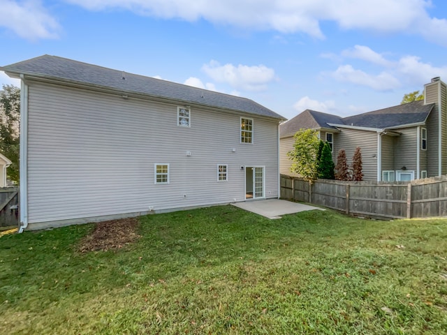 rear view of property featuring a yard and a patio area