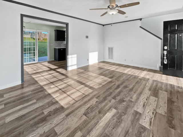 unfurnished living room featuring ceiling fan, ornamental molding, and wood-type flooring