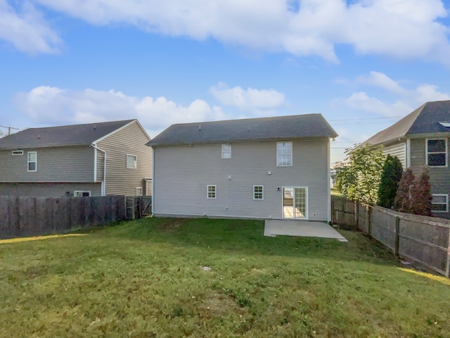 rear view of house featuring a lawn and a patio