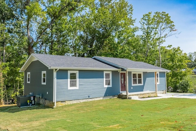 ranch-style house featuring a front lawn and central AC