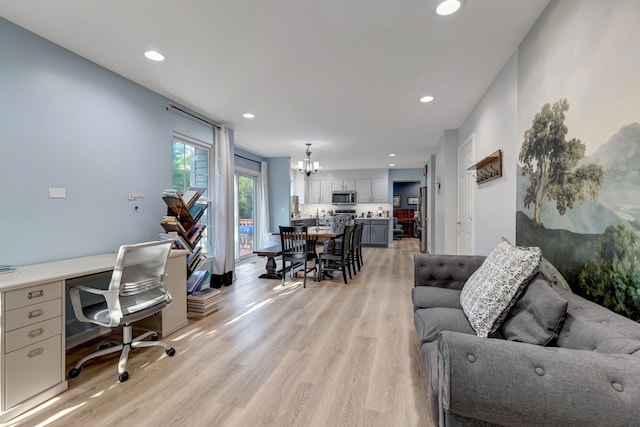 office area with light hardwood / wood-style floors and a notable chandelier