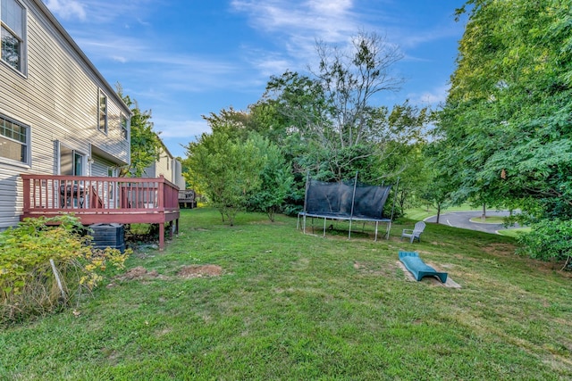 view of yard featuring a trampoline and a deck