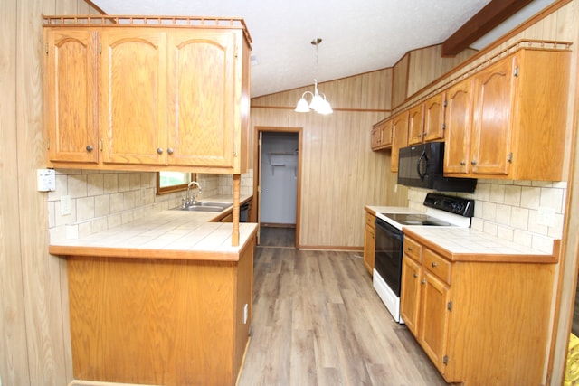 kitchen with wood walls, light hardwood / wood-style floors, tile counters, sink, and white range with electric stovetop