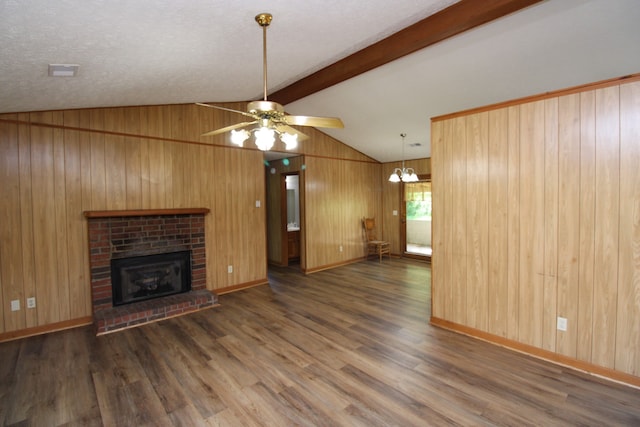 unfurnished living room featuring ceiling fan with notable chandelier, a fireplace, dark hardwood / wood-style flooring, and a textured ceiling