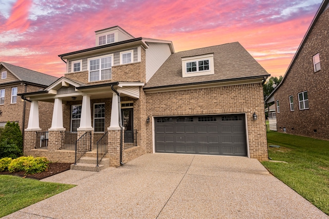 view of front of home featuring a garage, covered porch, and a lawn