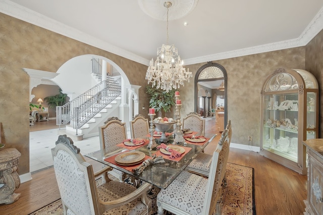 dining room featuring hardwood / wood-style floors, a chandelier, and crown molding