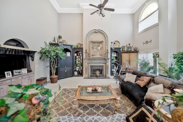 living room with a high ceiling, ceiling fan, carpet, and a premium fireplace