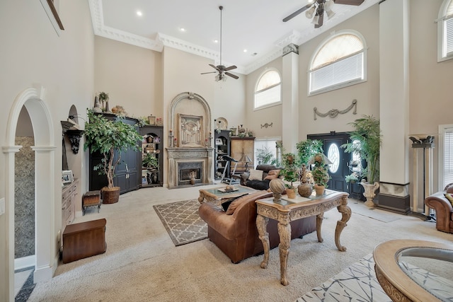 living room with light colored carpet, ceiling fan, and a high ceiling