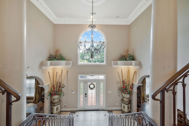 foyer featuring a wealth of natural light, crown molding, a notable chandelier, and wood-type flooring