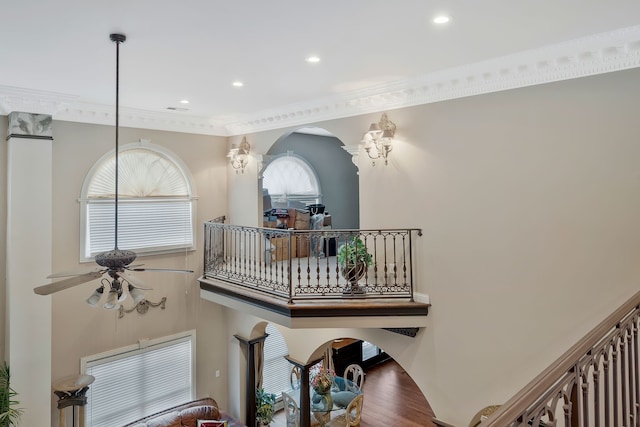 interior space featuring crown molding, ceiling fan with notable chandelier, and hardwood / wood-style floors