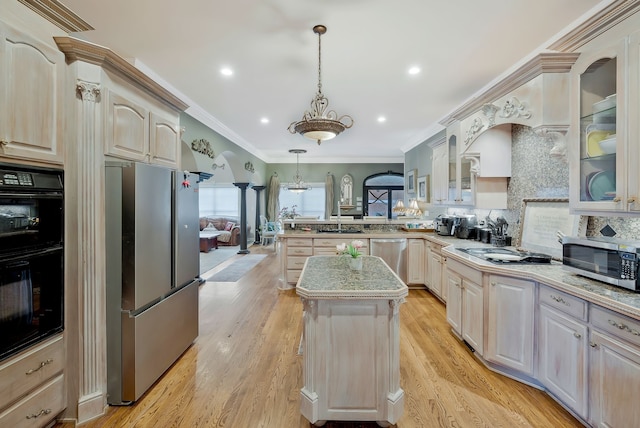 kitchen with crown molding, light hardwood / wood-style flooring, decorative light fixtures, appliances with stainless steel finishes, and kitchen peninsula