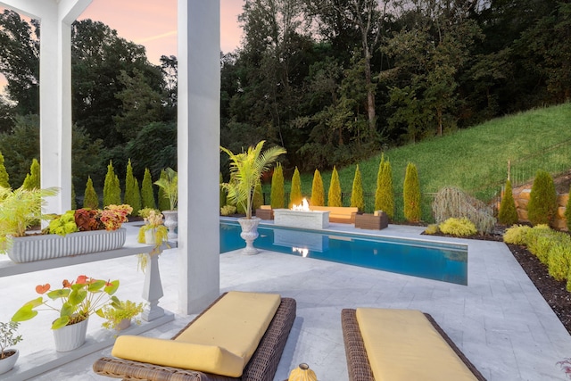 pool at dusk with a patio