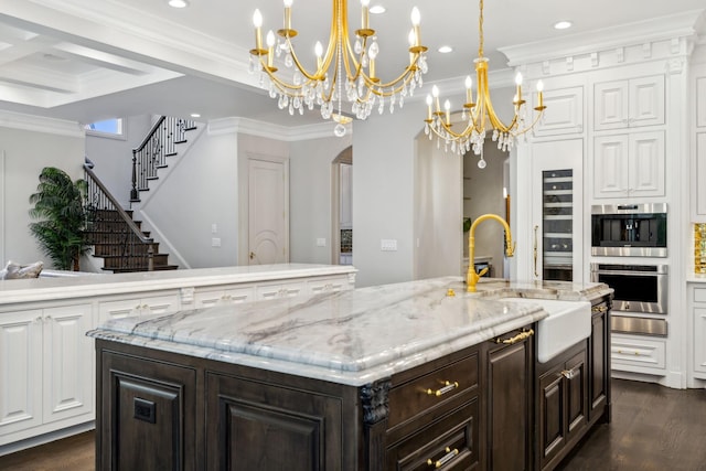 1077 Stockett Dr, Nashville, TN 37221 - kitchen featuring dark wood-style flooring, a center island with sink, a sink, arched walkways, and a notable chandelier