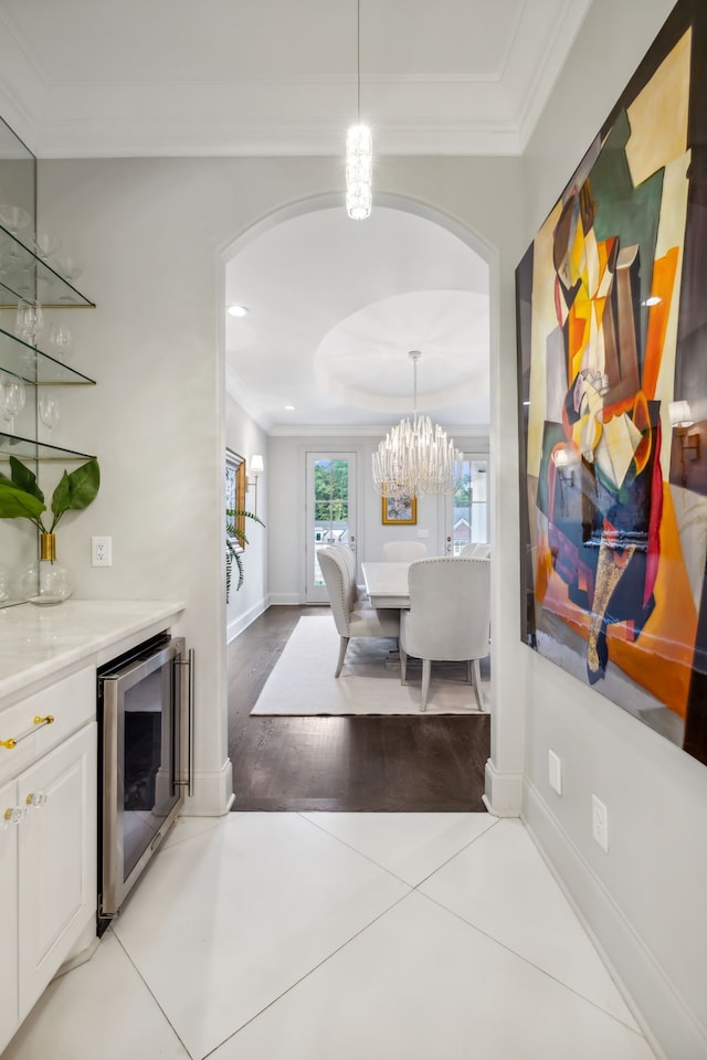 tiled dining area featuring beverage cooler and ornamental molding