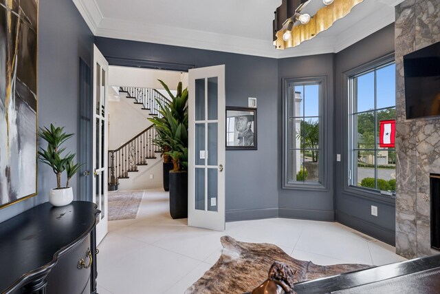 foyer with a fireplace, crown molding, and tile patterned flooring