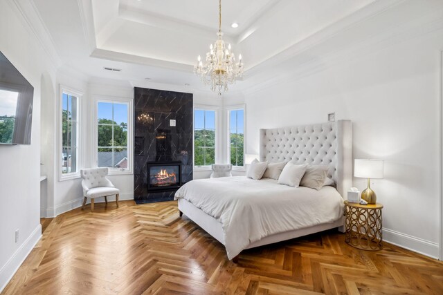 bedroom featuring a fireplace, ornamental molding, parquet flooring, and a tray ceiling