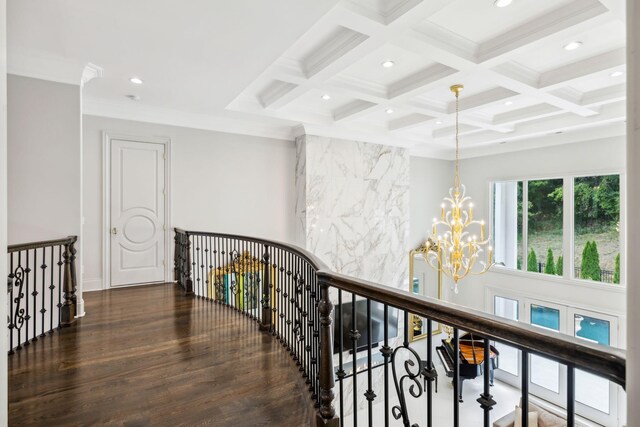 hallway with coffered ceiling, dark hardwood / wood-style flooring, a chandelier, and beam ceiling