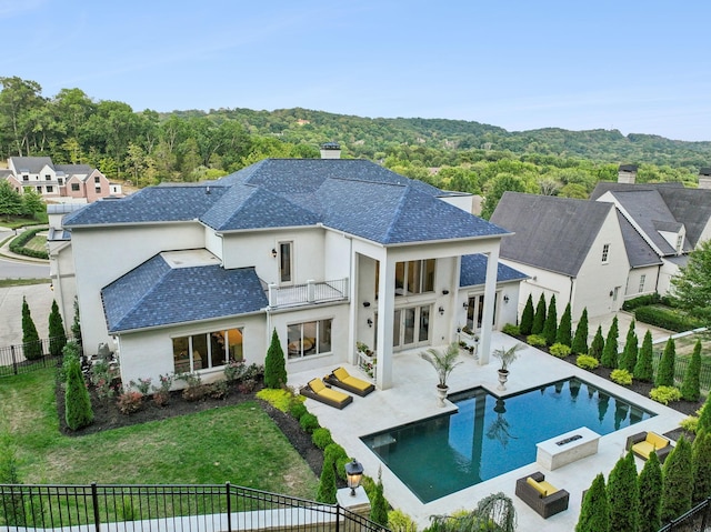 1077 Stockett Dr, Nashville, TN 37221 - back of property with a balcony, a fenced backyard, a lawn, and stucco siding