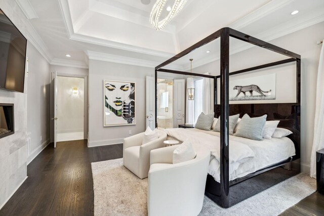 bedroom with crown molding, wood-type flooring, ensuite bath, and a chandelier