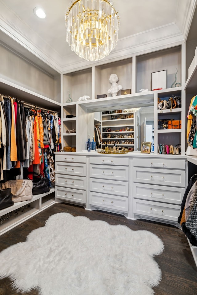 spacious closet featuring dark wood-type flooring and a notable chandelier