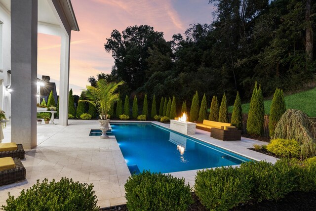 1077 Stockett Dr, Nashville, TN 37221 - pool at dusk with an outdoor pool, a patio area, and an outdoor living space with a fire pit