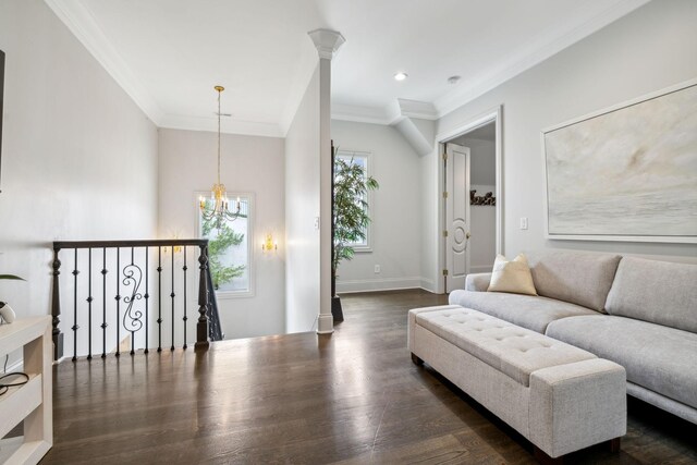 living room with dark wood-type flooring, ornamental molding, and a chandelier