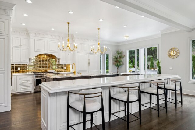 kitchen with an inviting chandelier, a center island with sink, pendant lighting, dark wood-type flooring, and high end range