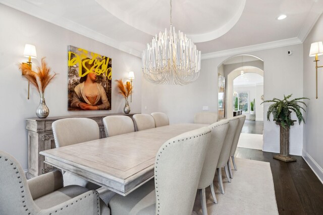 dining area featuring ornamental molding, an inviting chandelier, and dark hardwood / wood-style floors