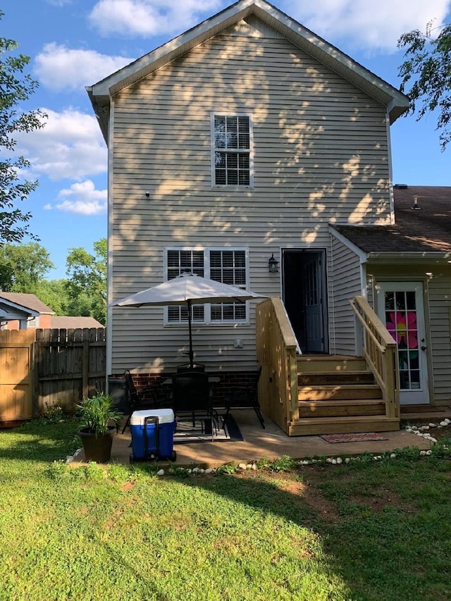 rear view of house featuring a yard and a patio