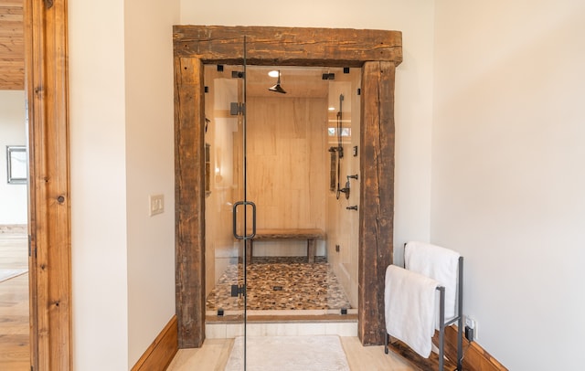 bathroom with a shower with door and wood-type flooring