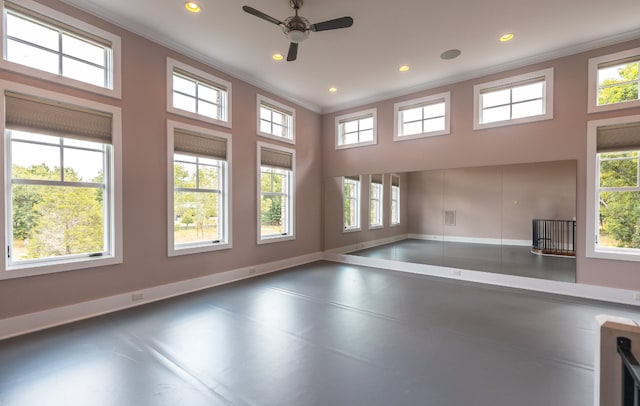 unfurnished living room featuring a towering ceiling, ceiling fan, ornamental molding, and concrete flooring