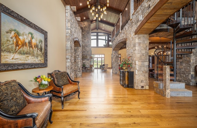 community lobby featuring high vaulted ceiling, beamed ceiling, wooden ceiling, and stairs