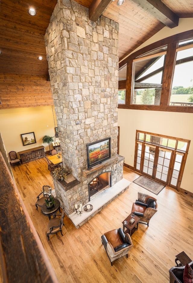 living room with a fireplace, beam ceiling, and light hardwood / wood-style floors