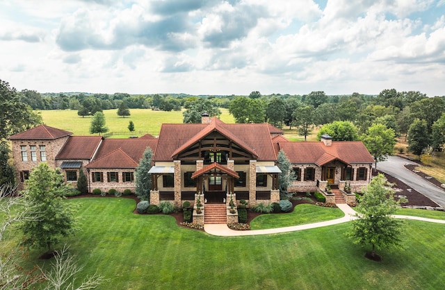 view of front of home featuring a chimney, stone siding, and a front lawn