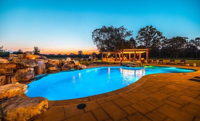 pool at dusk featuring a patio area