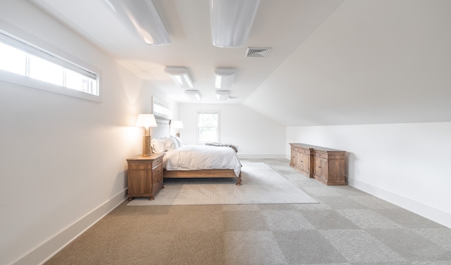 carpeted bedroom featuring lofted ceiling